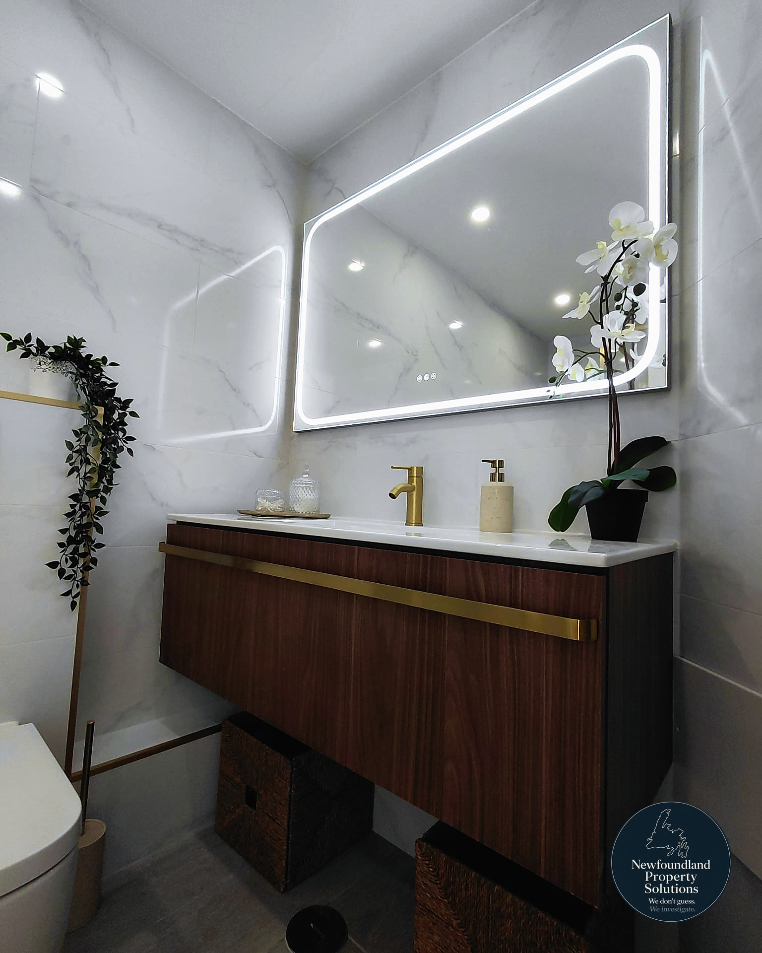 Walnut floating vanity with backlit mirror and brass tapware